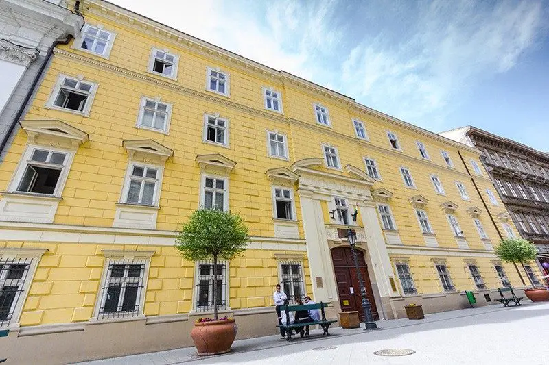 A Pannon Kincstár iskola sárga színű impozáns épülete egyedileg dizájnolt folyosókkal, tiszta tantermekkel.